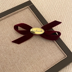 Eleganter burgunderroter Samt-Bogenhaarnadel mit goldenem handgemachtem Metallemblem