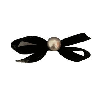 Elegant black velvet bow hair clip with a central pearl on a clean white background