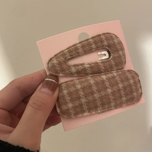 Close-up of retro brown plaid fabric hair clips set on pink display card