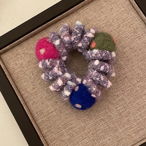 Détail de l'élastique cheveux tricoté arc-en-ciel avec boules colorées en laine feutrée
