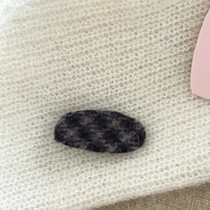 Vintage plaid plush oval hair clip with purple marble texture on white knit fabric