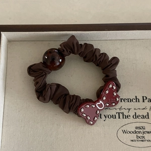 Retro scrunchie in brown fabric with dark red bow and tortoiseshell bead decoration