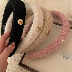 Détail de serre-têtes en peluche à carreaux avec boucle décorative en métal doré