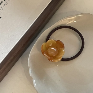 Detail of amber acetate flower hair tie with high elastic band on ceramic tray