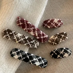 Detailed view of tweed plaid hair clips in oval and rectangular shapes for winter style