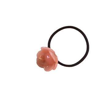 Elastic hair tie with pink acetate flower charm on minimalist black high-stretch cord
