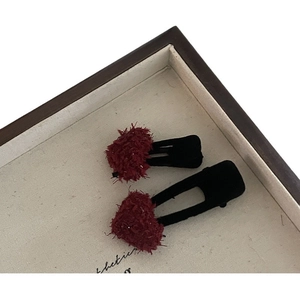 Vintage burgundy velvet pom-pom hair clips set in a wooden display tray for women