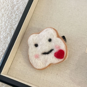 Détail macro d'une pince à cheveux en feutre de toast mignon avec un cœur rouge