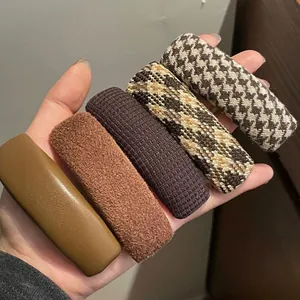 Detail of 5-piece houndstooth and leather hair clips set in warm autumn colors