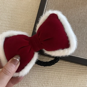 Red velvet hair scrunchie with white faux fur trim and bow design for winter