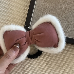 Detail of soft velvet bow hair clip with plush faux fur trim on a high-elastic hair tie