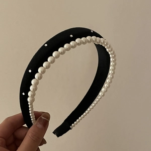 Detail of black velvet headband featuring white faux pearls and small rhinestones