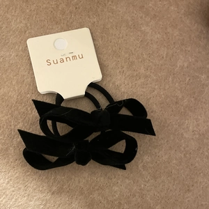 Detailed view of two-piece black velvet bow hair scrunchies on Suanmu display card
