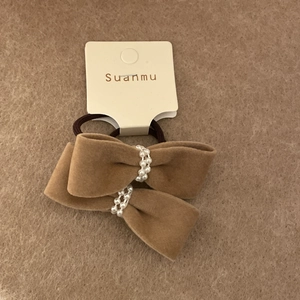 Detailed close-up of burgundy velvet bow hair ties with elegant white pearl center accents
