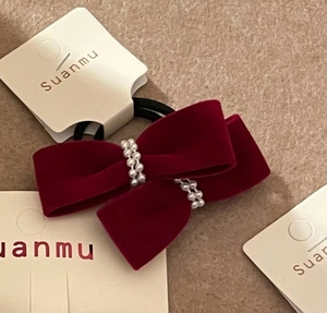 Close-up of wine red velvet bow hair tie featuring two rows of delicate faux pearls