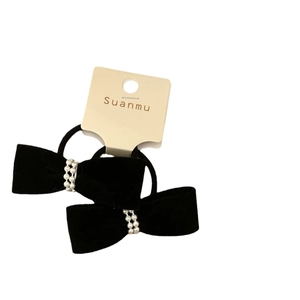 Set of two black velvet bow hair ties with pearl bead embellishments on card
