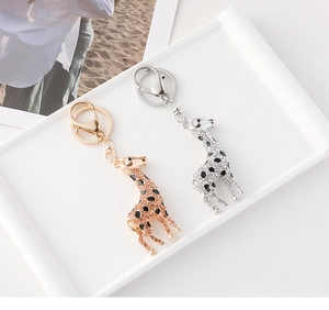 Detailed macro view of crystal-encrusted giraffe keychains with enamel spots and lobster claws