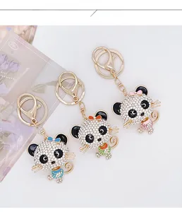Detailed view of three luxury diamond-encrusted cartoon cat keychains with gold lobster clasps