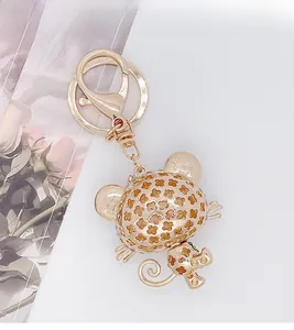 Detail of gold-plated alloy panda cat keychain with hollow floral pattern and rhinestones