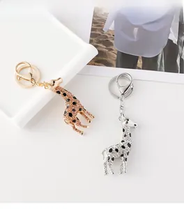 Detail of giraffe keychains with inlaid rhinestones and black enamel dots in gold and silver