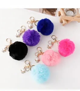 Portachiavi con pompon in ecopelliccia colorata con ciondoli angelo e ganci dorati