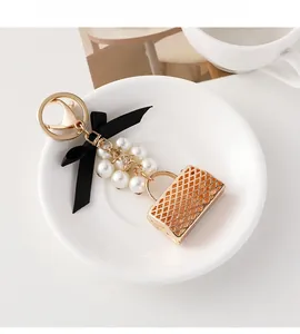 Vue détaillée d'un porte-clés sac doré avec des perles et un nœud sur une assiette