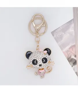 Close-up of diamond-studded panda keychain with pink bow and sparkling rhinestones