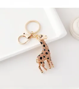 Detailed close-up of golden giraffe keychain with champagne rhinestones and black enamel dots