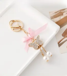 Vue macro détaillée d'un porte-clés papillon étincelant avec strass et perles blanches