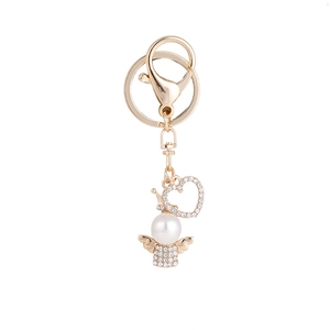 Elegant gold angel keychain with white pearl body and sparkling heart pendant for baptism