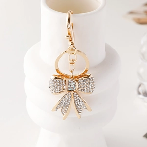 Porte-clés nœud doré avec pendentif Lettre D strass sur vase en céramique blanc