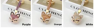 Close-up of fox-shaped keychains with rhinestones and pearls in purple, orange and white