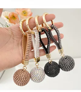 Detail of crystal ball keychains in rose gold and silver held in a home setting