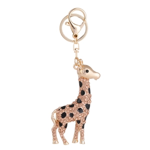 Golden giraffe keychain with champagne rhinestones and black enamel spots on white background
