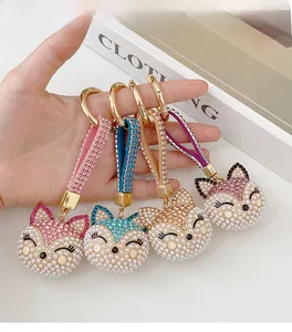 Detailed view of fox keychain featuring pink, blue, and gold rhinestone-studded straps