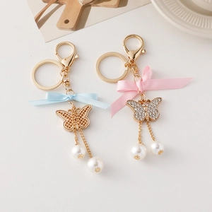 Porte-clés papillon élégant avec perles, strass et rubans de satin bleu ou rose