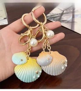 Détail d'un porte-clés avec perles et coquillages dégradés sur une surface en bois brun