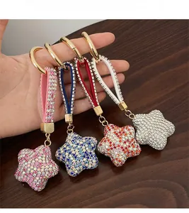 Détail de quatre porte-clés étoiles en strass avec anneau doré et lanières en cristal