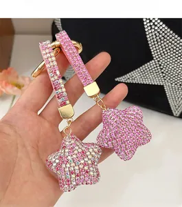Vue détaillée du porte-clés étoile en strass rose scintillant sur un sac à main