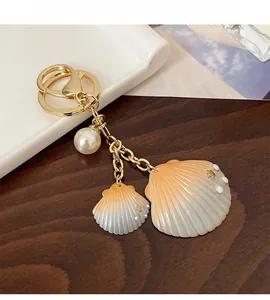 Détail du porte-clés coquillage avec perle et pendentifs dégradés orange vif