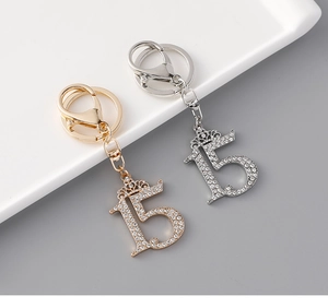 Detailed close-up of rhinestone encrusted number 15 keychains in gold and silver finish
