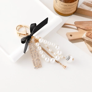 Elegante portachiavi con fiocco, perle e ciondolo KISS per borse da donna raffinate