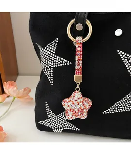Charm en forme d'étoile avec strass étincelants attaché à un sac en toile noire élégant