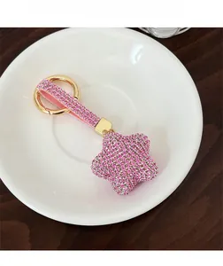 Vue détaillée d'un porte-clés étoile en strass rose avec anneau en métal doré