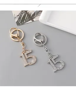 Detail showing crystal rhinestone crown number 15 keychains in gold and silver finish