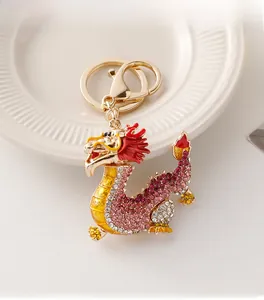 Détail du porte-clés dragon doré orné de strass roses et de finitions en émail