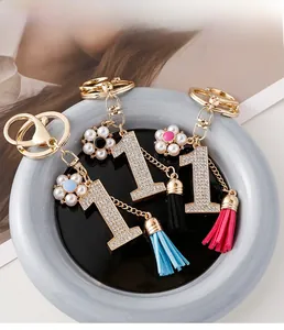 Vue détaillée de porte-clés numéro 1 faits main avec diamants, fleurs et pompons