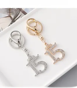Detailed macro view of rhinestone-encrusted number 15 crown keychains in gold and silver