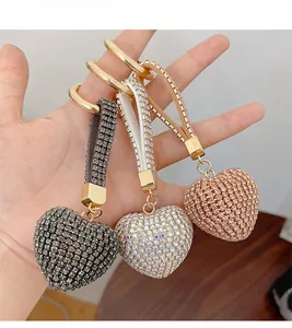 Close-up of heart keychains with full rhinestones in grey silver and gold colors