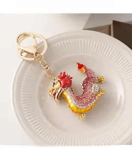 Détail du porte-clés dragon avec strass roses et émail sur un plateau en céramique